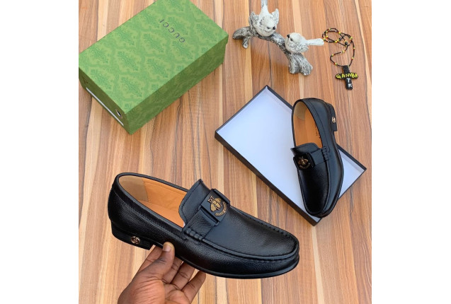 Black Loafer with a Metal Emblem.